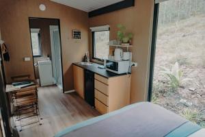 una pequeña cocina con fregadero y microondas en Wilderness View, en Mooloolah