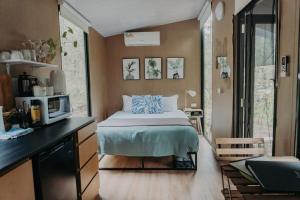 ein kleines Schlafzimmer mit einem Bett und einer Mikrowelle in der Unterkunft Wilderness View in Mooloolah