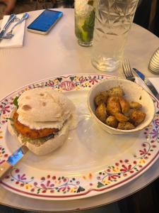 a plate with a sandwich and a bowl of potatoes at The G.S. Cottages in Shimla