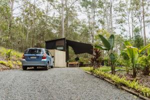 a car parked in front of a tiny house at Wilderness View in Mooloolah