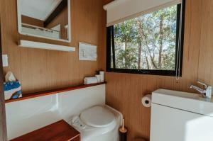 La salle de bains est pourvue de toilettes, d'un lavabo et d'une fenêtre. dans l'établissement Wildlife Haven, à Agnes Water