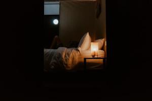 a bed with a lamp on a table in a dark room at Wildlife Haven in Agnes Water