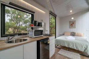 una cocina con fregadero y una cama en una habitación en The Meadows Tiny House, en Macclesfield