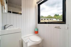 uma pequena casa de banho com um WC e uma janela em The Meadows Tiny House em Macclesfield