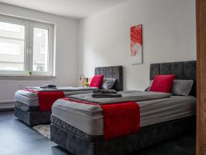 two beds in a room with red pillows at SR24 - Wohnung in Duisburg 4 in Duisburg