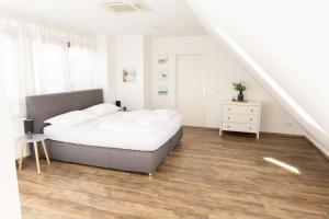 1 dormitorio blanco con 1 cama y escalera en BeMyGuest - 3 Zimmer Maisonette - Zentral - Klimaanlage - Aufzug, en Wiesbaden