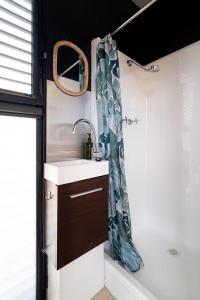 a bathroom with a sink and a shower curtain at Tiny Divine Farmstay in Korweinguboora