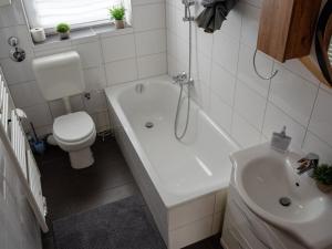 a bathroom with a toilet and a tub and a sink at SR24 - Wohnung in Duisburg 4 in Duisburg