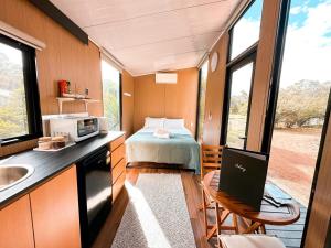 a small room with a bed and a kitchen with a laptop at Wally's Retreat 2 in Balingup