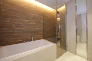 uma casa de banho com uma banheira e um chuveiro em vidro. em New Arabian Bluewater em Dubai