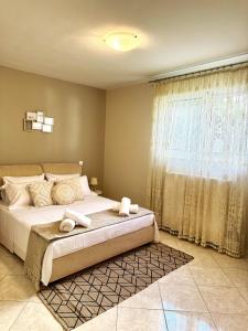 ein Schlafzimmer mit einem großen Bett und einem Fenster in der Unterkunft Villa Korina in Posidhonía
