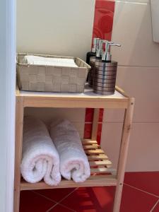 ein Holzregal mit Handtüchern im Bad in der Unterkunft Villa Korina in Posidhonía