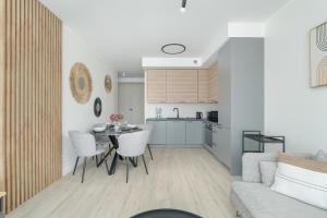 a kitchen and a living room with a table and chairs at Family Apartment in Poznań with 2 Parking Spaces, 3 Bedrooms and Balcony by Renters in Poznań