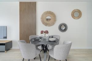 a dining room with a black table and chairs at Family Apartment in Poznań with 2 Parking Spaces, 3 Bedrooms and Balcony by Renters in Poznań
