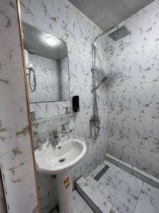 bagno bianco con lavandino e specchio di Guest House Medic a Nukus