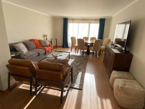 sala de estar con sofá y mesa en Hillside Haven: Elegant Modern 2 BR Condo w/ Pool, en Funchal