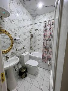 Baño blanco con aseo y lavamanos en Guest House Medic, en Nukus