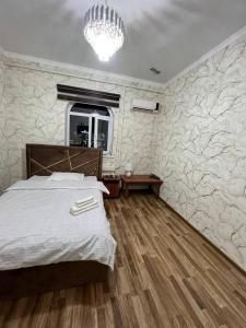 una camera con letto e lampadario a braccio di Guest House Medic a Nukus