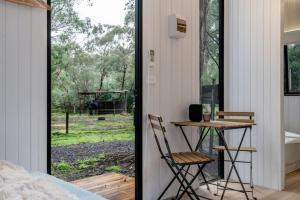 a bedroom with a table and chairs next to a window at Mountain Ash Cabin 