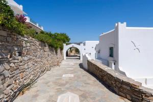 a stone alleyway between two white buildings at Parikia Cove Mansion in Parikia