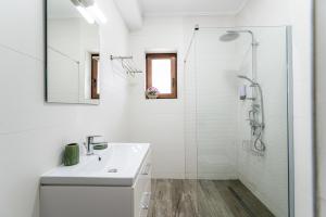 a white bathroom with a sink and a shower at Cross Caraiman View 1 in Buşteni +77 photos