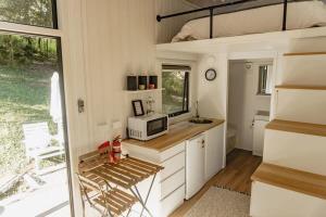 a kitchen with a microwave and a sink in a tiny house at Mary Valley Views in Amamoor