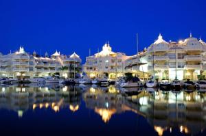 a large building with boats in a marina at night at Duplex Penthouse with Seaview. in Benalmádena
