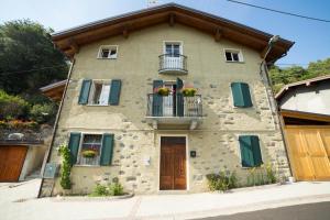 - un bâtiment avec un balcon et des fleurs dans l'établissement B&B Ca' La Vedescia, à Teglio