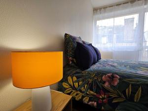 een slaapkamer met een bed en een lamp op een tafel bij Le cosy duplex centre in Dinan