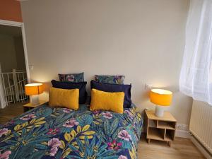 una camera da letto con un letto con due lampade sopra di Le cosy duplex centre a Dinan