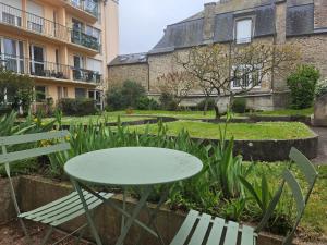 a table and chairs in front of a building at Le cosy duplex centre in Dinan