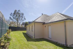 uma pequena casa branca com um jardim de relva em Villa - Spa Terre et Mer em Landévant