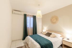 1 dormitorio con 1 cama grande y cortinas verdes en sunny, en Saint-Gilles-les-Bains