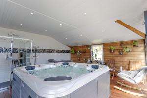 uma grande banheira num quarto com uma cozinha em Villa - Spa Terre et Mer em Landévant