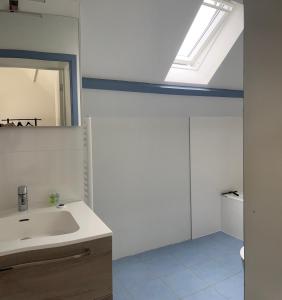 Baño blanco con lavabo y espejo en Ecole Buissonnière, en Vielsalm