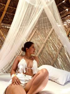a woman in a bikini sitting on a bed at Casa Alma in Capurganá