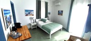 a small bedroom with a bed and a table at Agora Center Building - Room 14 in Ios Chora