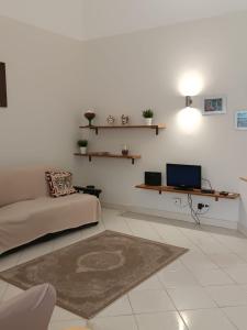 sala de estar con sofá y TV en Mosa House, en Aci Castello