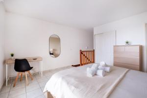 Habitación blanca con cama y escritorio en Luxueux Appartement à La Défense, en Courbevoie