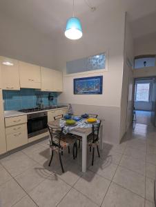 eine Küche mit einem Tisch und einigen Stühlen sowie einem Tisch und einer Küche in der Unterkunft Casa Mazzini in Termoli