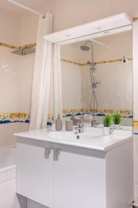 Baño blanco con lavabo y espejo en Luxueux Appartement à La Défense, en Courbevoie