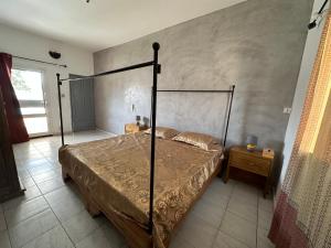 a bedroom with a bed with a metal frame at Villa du Bonheur in Sali Nianiaral