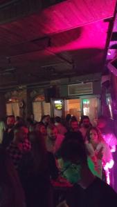 a crowd of people sitting in a room with pink lights at Kultura Hostel in Shkodër