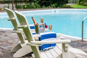 uma mesa com uma garrafa de vinho e copos ao lado de uma piscina em Ballymaloe House Hotel em Ballycotton