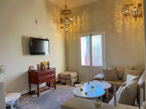 sala de estar con sofá y TV en Noubti en Marrakech