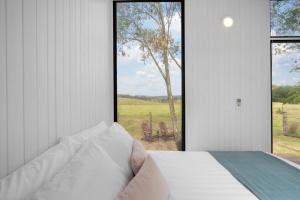 a bedroom with a bed and a large window at The Stockmans Camp 1 - Sunset Tiny House in Buchan