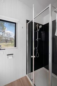 a shower in a bathroom with a window at The Stockmans Camp 1 - Sunset Tiny House in Buchan