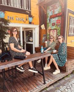 a group of three women sitting at a wooden bench at The Local in Istanbul