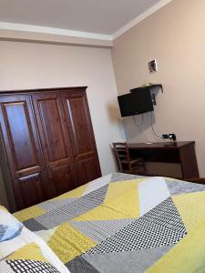 1 dormitorio con 1 cama, vestidor y TV en Agriturismo Vecchio Torchio, en Canelli
