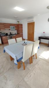 a dining room table with white chairs and a blue and white table at Apartman Linda in Milna